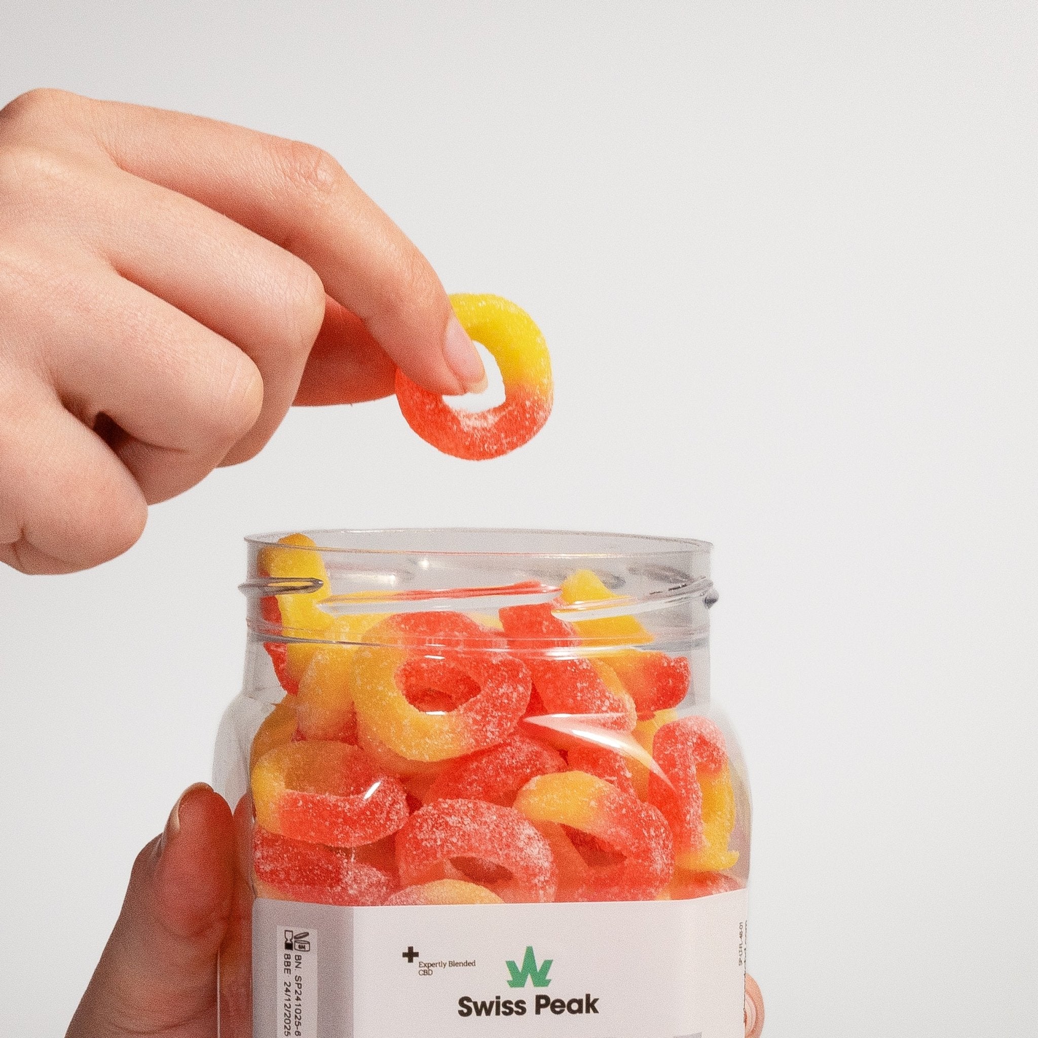 Close up handing holding CBD Peach Ring Gummies 3200mg - 4800mg - Swiss Peak