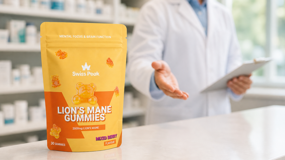 Close-up of Swiss Peak Health Lion’s Mane Gummies in an open tub with one gummy in hand, set on a tidy UK home workspace.